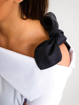 Biała bluzka z czarną kokardą na ramieniu